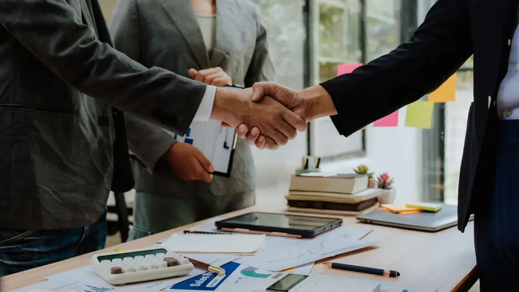 Business leaders shaking hands to close a deal