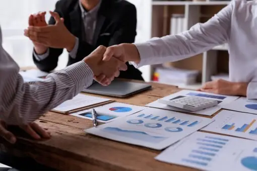 Business leaders shaking hands to close a merger