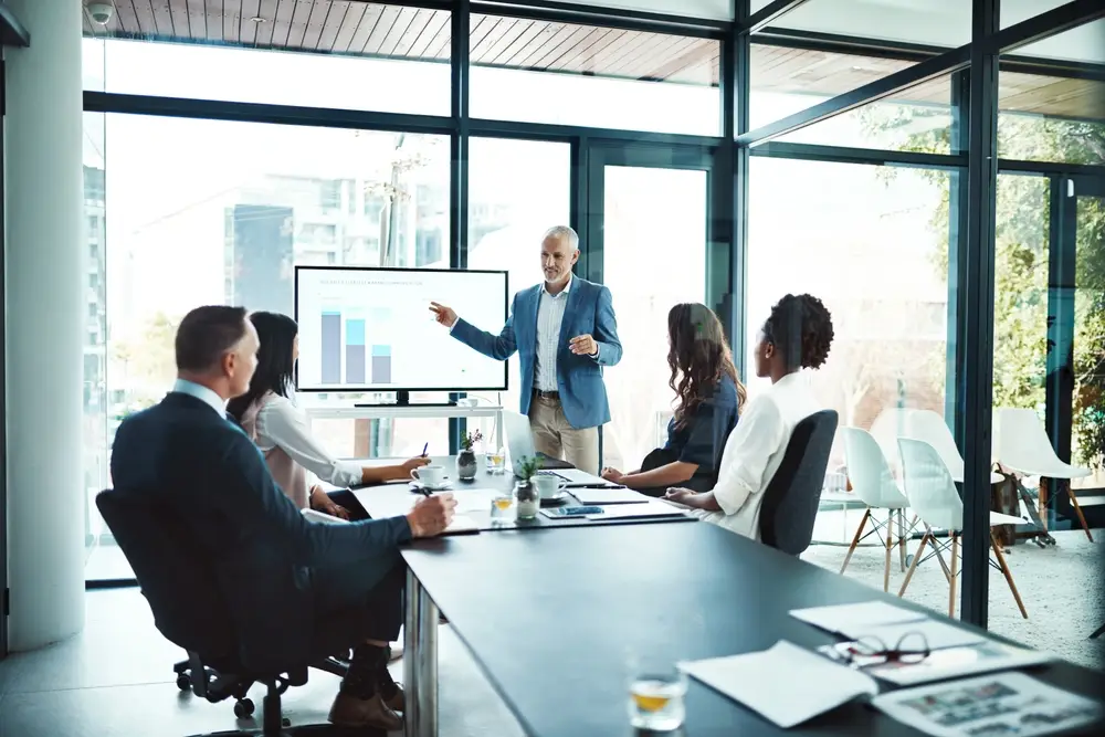 Business, charts and man with presentation, office and conversation for project, profit growth and meeting. Male leader, staff or group with teamwork, graphs or partnership in a boardroom or planning